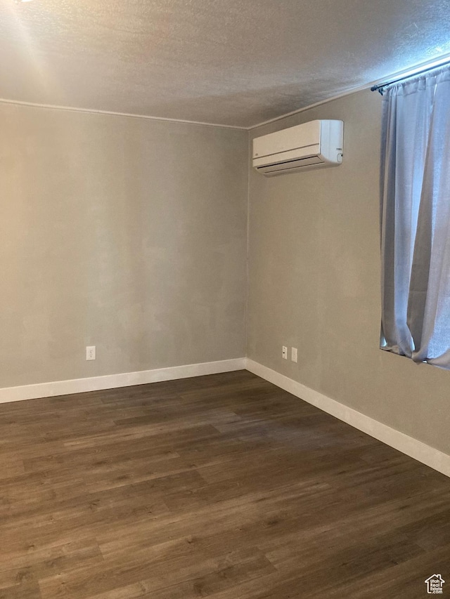 2855 Lincoln Ave, Ogden, UT 84401 - unfurnished room featuring dark wood finished floors, baseboards, an AC wall unit, and a textured ceiling