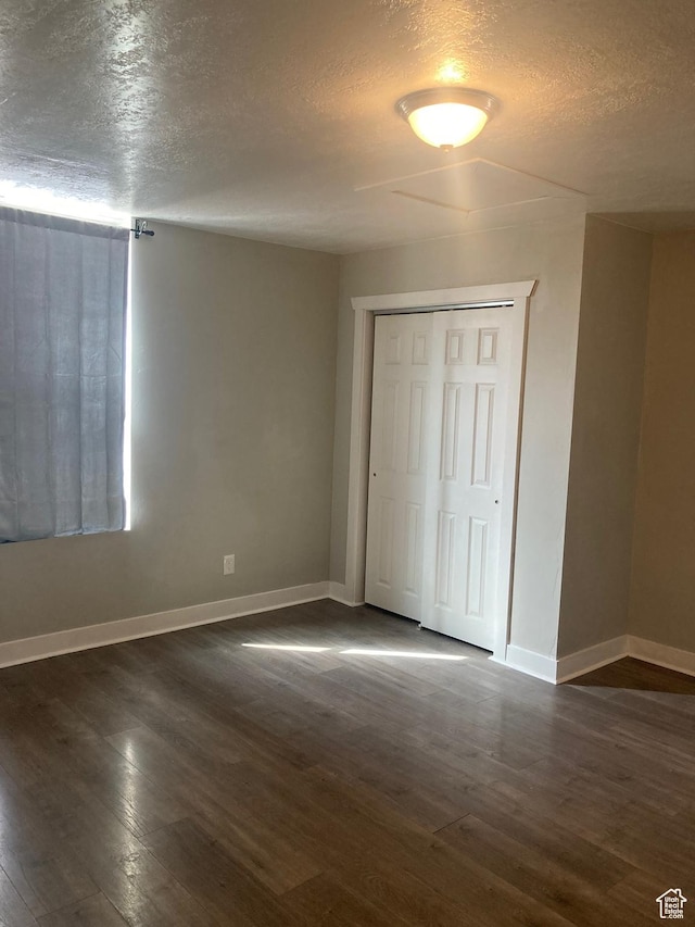 2855 Lincoln Ave, Ogden, UT 84401 - unfurnished bedroom featuring baseboards, a textured ceiling, and dark wood-style flooring