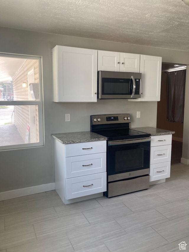 2855 Lincoln Ave, Ogden, UT 84401 - kitchen with white cabinets, stainless steel appliances, and stone counters
