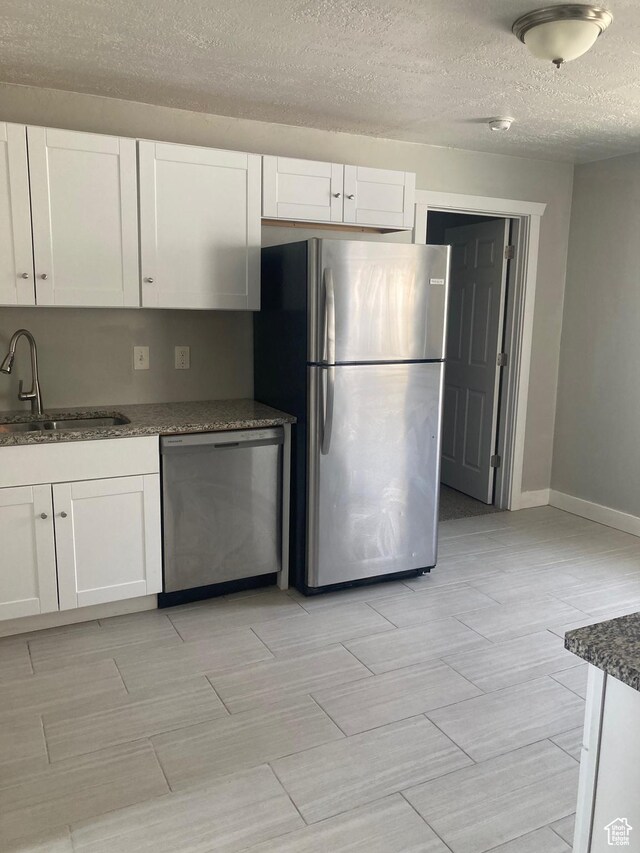2855 Lincoln Ave, Ogden, UT 84401 - kitchen with white cabinets, a sink, appliances with stainless steel finishes, and dark stone countertops