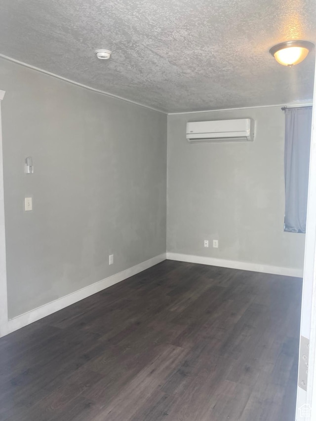 2855 Lincoln Ave, Ogden, UT 84401 - spare room with a wall mounted AC, dark wood-style floors, baseboards, and a textured ceiling