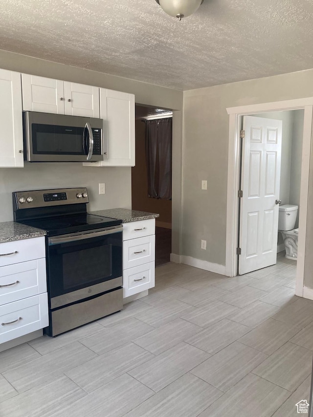 2855 Lincoln Ave, Ogden, UT 84401 - kitchen with white cabinets, stone counters, and stainless steel appliances