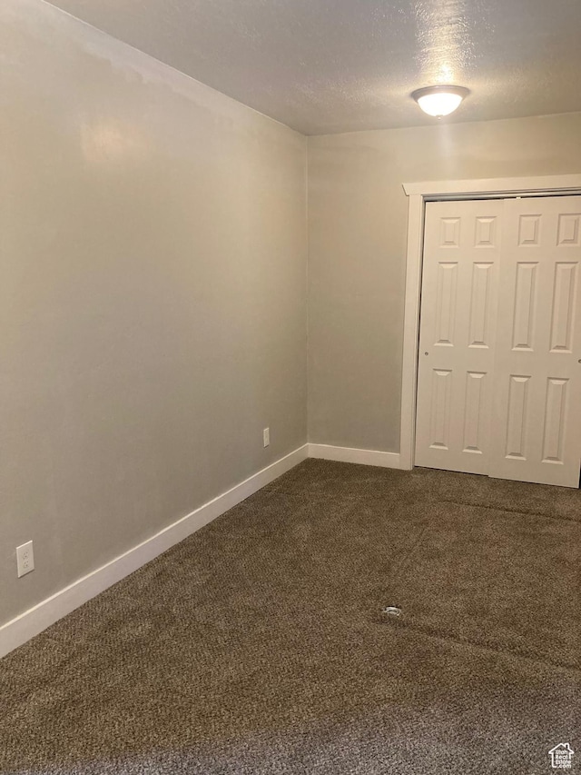 2855 Lincoln Ave, Ogden, UT 84401 - spare room with baseboards, a textured ceiling, and dark carpet