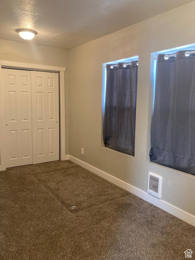 2855 Lincoln Ave, Ogden, UT 84401 - unfurnished bedroom featuring a closet, a textured ceiling, baseboards, visible vents, and carpet