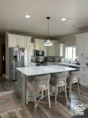 4190 W Delray N Unit 39, Vernal, UT 84078 - kitchen featuring recessed lighting, light countertops, a breakfast bar area, dark wood finished floors, and appliances with stainless steel finishes