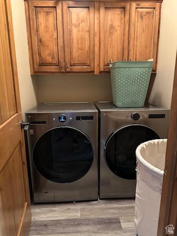 4190 W Delray N Unit 39, Vernal, UT 84078 - clothes washing area featuring cabinet space, washing machine and dryer, and light wood-style floors
