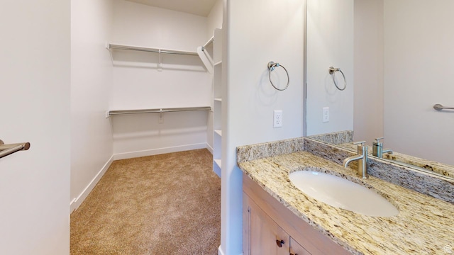 2696 W 2495 S Unit 207, Syracuse, UT 84075 - bathroom featuring baseboards, a walk in closet, and vanity