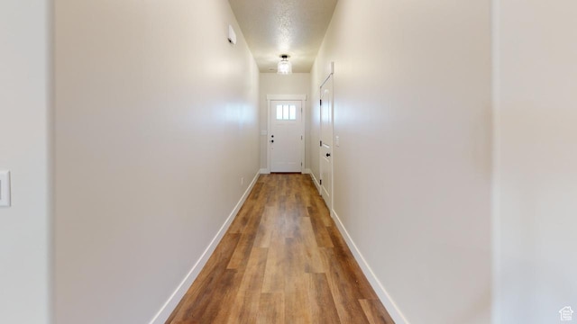 2696 W 2495 S Unit 207, Syracuse, UT 84075 - corridor with baseboards, a textured ceiling, and wood finished floors