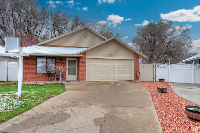 1077 E Deerwalk Ln S, Ogden, UT 84404 - view of front of home featuring fence, an attached garage, driveway, a gate, and brick siding