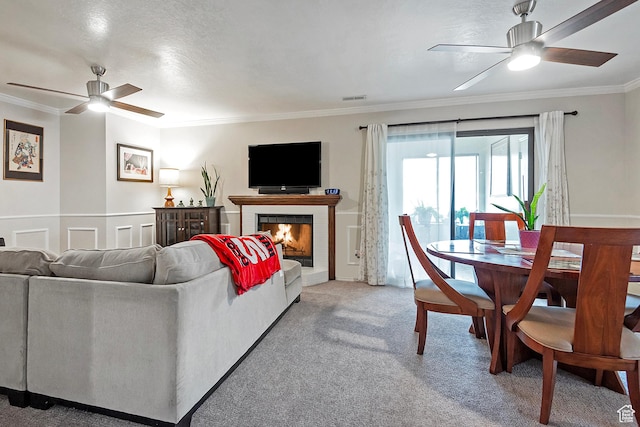 1077 E Deerwalk Ln S, Ogden, UT 84404 - living room with a fireplace, ornamental molding, a ceiling fan, and light carpet