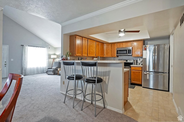 1077 E Deerwalk Ln S, Ogden, UT 84404 - kitchen with light countertops, a breakfast bar area, stainless steel appliances, a peninsula, and brown cabinetry