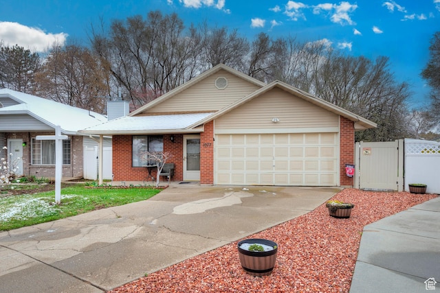 ranch-style house with concrete driveway, a gate, brick siding, a garage, and a chimney