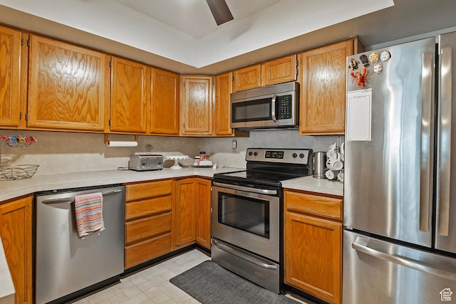 1077 E Deerwalk Ln S, Ogden, UT 84404 - kitchen featuring light countertops, brown cabinetry, a ceiling fan, and appliances with stainless steel finishes