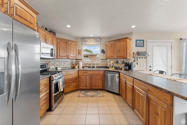 6832 W 1500 N, Cedar City, UT 84721 - kitchen featuring a sink, backsplash, appliances with stainless steel finishes, brown cabinets, and dark countertops