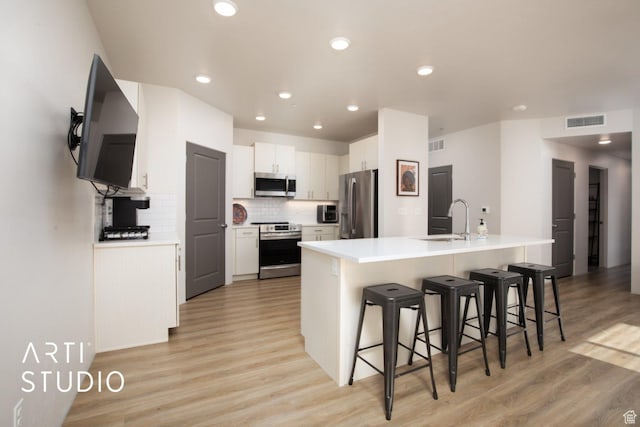76 E 450 N, Ephraim, UT 84627 - kitchen featuring a sink, white cabinetry, a kitchen bar, appliances with stainless steel finishes, and visible vents