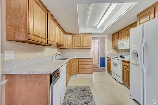 kitchen with white appliances, light countertops, a sink, and light tile patterned floors