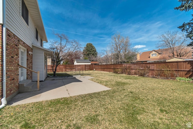view of yard with entry steps, a patio area, and a fenced backyard