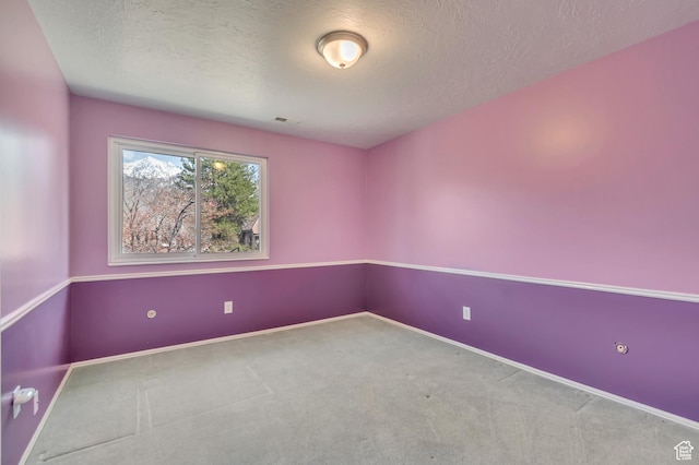 empty room with visible vents, baseboards, carpet flooring, and a textured ceiling