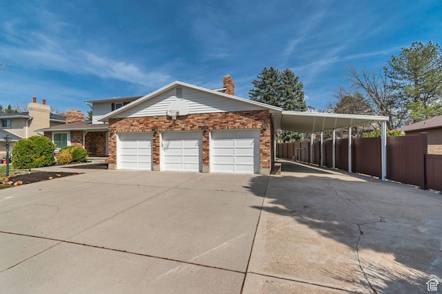 view of front of house with concrete driveway, a garage, fence, and brick siding