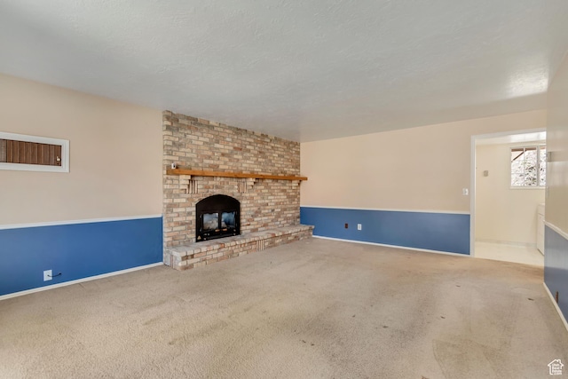 unfurnished living room featuring a textured ceiling, a fireplace, baseboards, and carpet floors