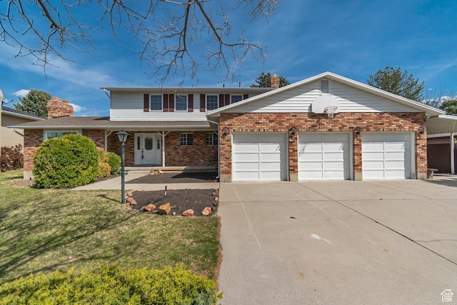 traditional-style house with a front yard, brick siding, a chimney, a garage, and concrete driveway
