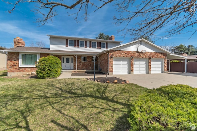 traditional home featuring a front yard, brick siding, an attached garage, a chimney, and concrete driveway