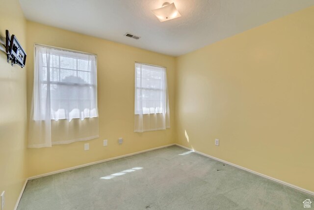 unfurnished room featuring baseboards, visible vents, and carpet floors