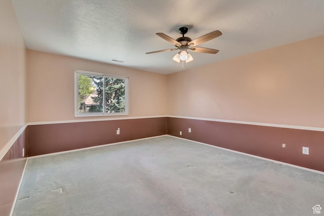 carpeted empty room featuring visible vents, baseboards, and a ceiling fan