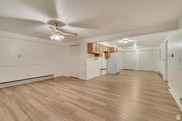 unfurnished living room with a textured ceiling, light wood-type flooring, baseboard heating, and a ceiling fan