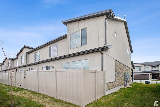 1960 W Jaydin Way S Unit 1, West Haven, UT 84401 - back of property featuring a lawn, stucco siding, fence, and stone siding