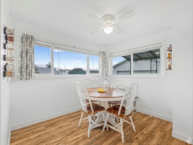 dining area with a ceiling fan, baseboards, and wood finished floors
