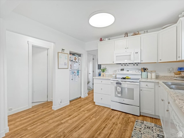kitchen with white cabinetry, light countertops, white appliances, a sink, and light wood finished floors