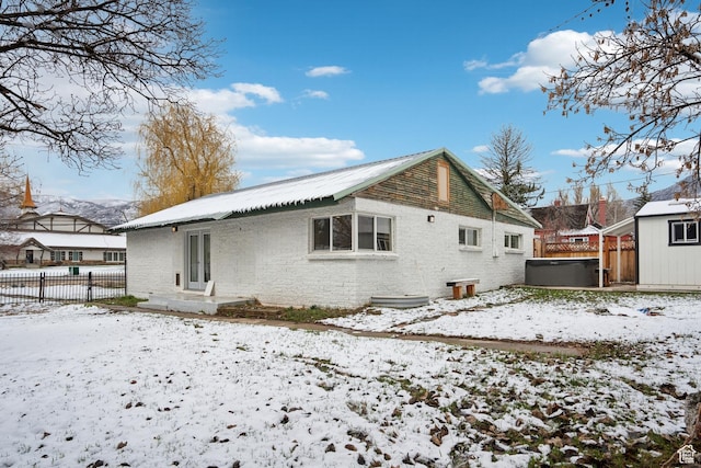 148 N Center St, Midway, UT 84049 - snow covered property featuring an outbuilding, fence, a hot tub, metal roof, and brick siding