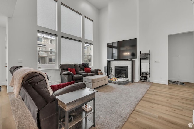 16132 S Coupler Ln Unit 406, Bluffdale, UT 84065 - living area featuring baseboards, a high ceiling, wood finished floors, and a brick fireplace