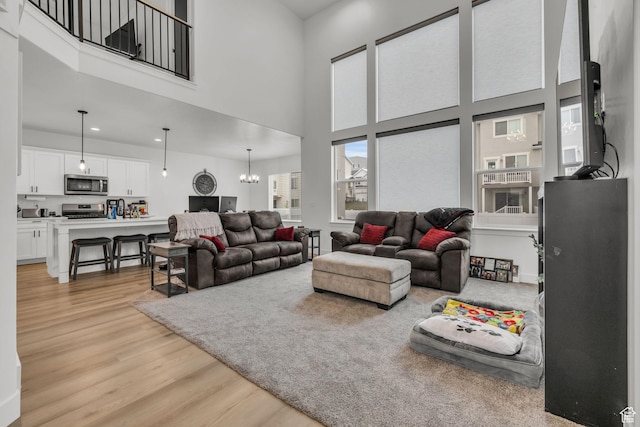 16132 S Coupler Ln Unit 406, Bluffdale, UT 84065 - living area featuring an inviting chandelier, light wood-style flooring, and a high ceiling