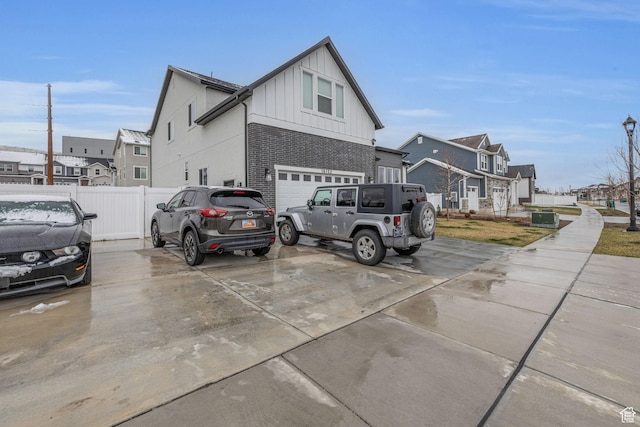 16132 S Coupler Ln Unit 406, Bluffdale, UT 84065 - view of home's exterior featuring fence, an attached garage, concrete driveway, board and batten siding, and a residential view