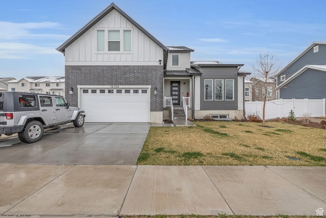 view of front of house featuring fence, an attached garage, concrete driveway, a front lawn, and board and batten siding