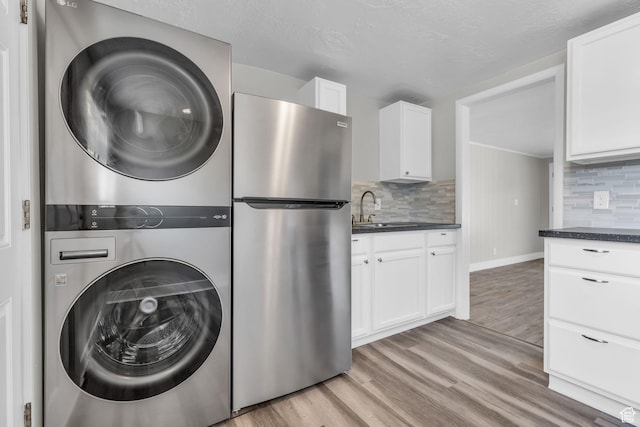 2620 S 8590 W, Magna, UT 84044 - laundry area featuring a sink, light wood-style floors, laundry area, and stacked washer / drying machine