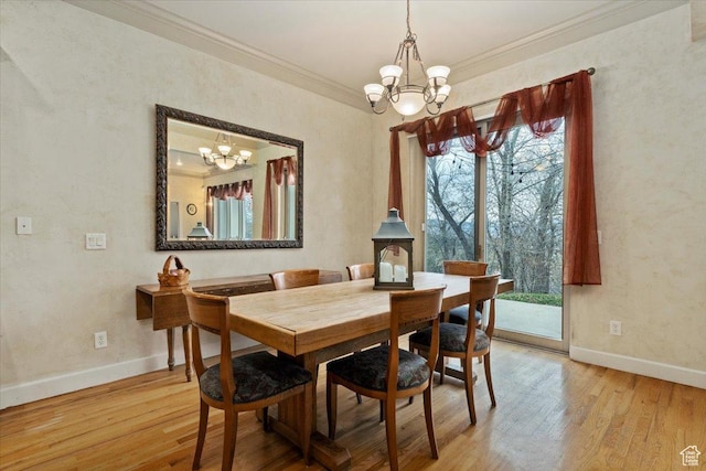 dining space featuring an inviting chandelier, light wood-style floors, and crown molding