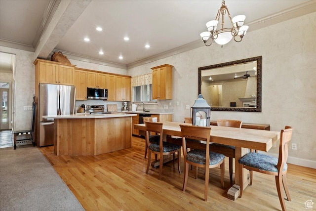 kitchen with light countertops, a chandelier, stainless steel appliances, a kitchen island, and light wood-style floors