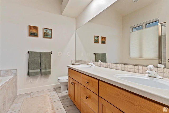 bathroom with double vanity, tiled tub, toilet, and a sink
