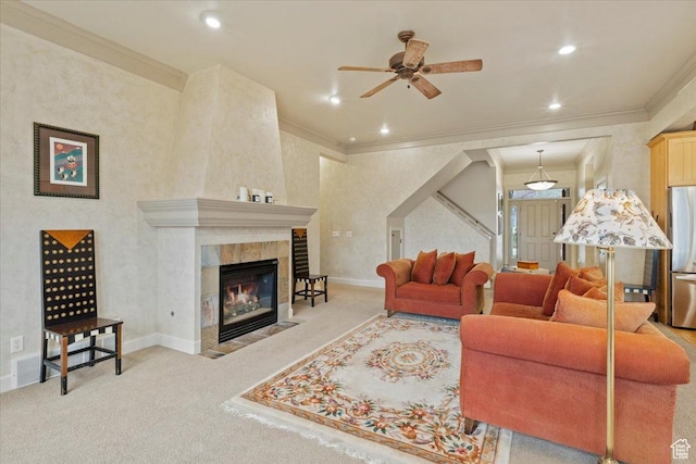 carpeted living room featuring ornamental molding, a tiled fireplace, ceiling fan, and recessed lighting