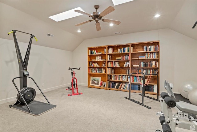 exercise area with visible vents, vaulted ceiling with skylight, carpet, and a ceiling fan