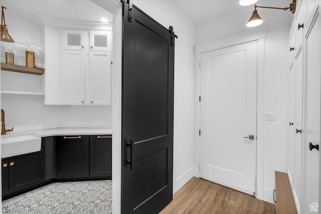 697 E Margarita Way, Washington, UT 84780 - interior space featuring light countertops, white cabinets, a barn door, a sink, and dark cabinets