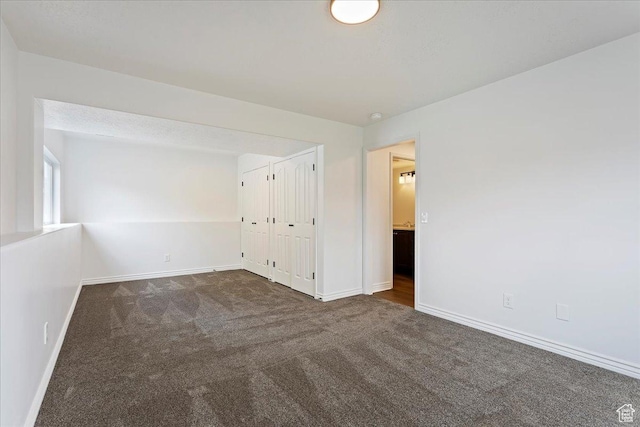 unfurnished bedroom with baseboards, a closet, and carpet