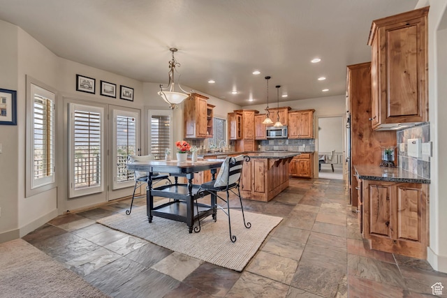 dining room with stone tile floors, baseboards, and recessed lighting