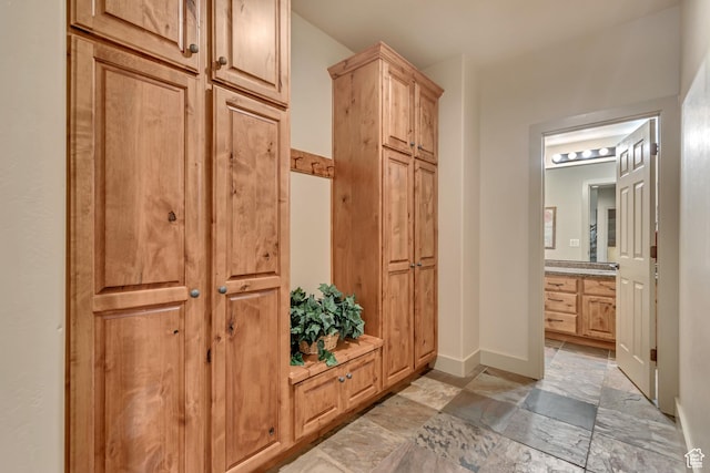mudroom featuring baseboards and stone finish flooring