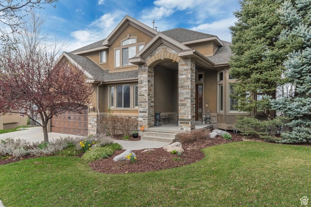 view of front of property featuring stone siding, concrete driveway, a front yard, stucco siding, and a shingled roof