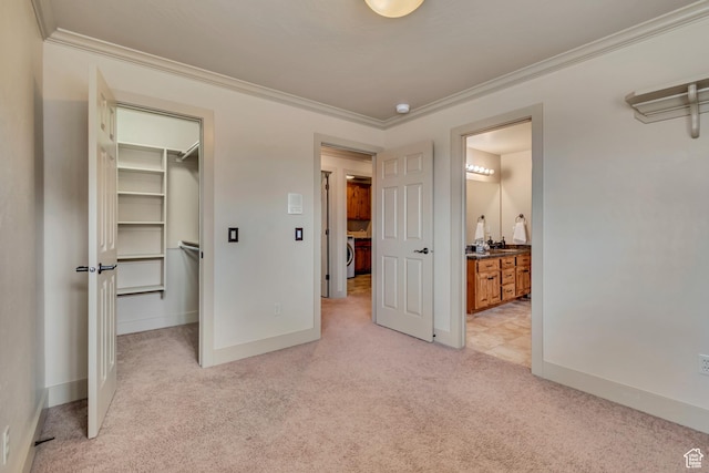 unfurnished bedroom featuring baseboards, ornamental molding, a walk in closet, and light carpet
