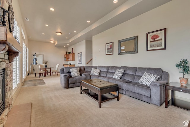 living area with visible vents, a fireplace, stairway, recessed lighting, and light carpet